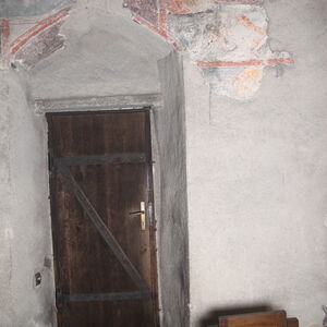 Remains of two unidentified figures on the left and on the right side of the entrance