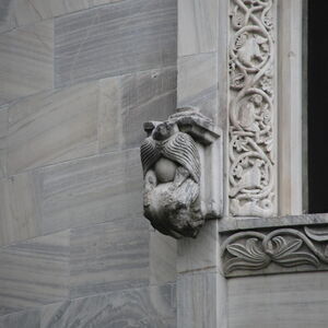 Kneeling figure on the south side of the window