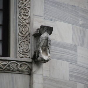 Kneeling figure on the north side of the window