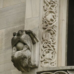 Kneeling figure on the south side of the window